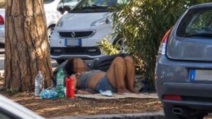 Donna senza dimora in un giaciglio di fortuna tra le aiuole di Ostia, nella zona di piazza Tolosetto Farinati degli Uberti