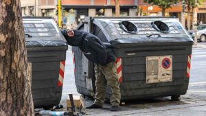 Persona tra i cassonetti in Viale Marconi a Roma, nella segnalazione sulla marginalità sociale del 24 settembre 2026
