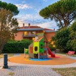 Area giochi riqualificata del Parco della Pace tra i Popoli a Colle del Sole, Roma, con scivolo, struttura ludica e pavimentazione antitrauma.
