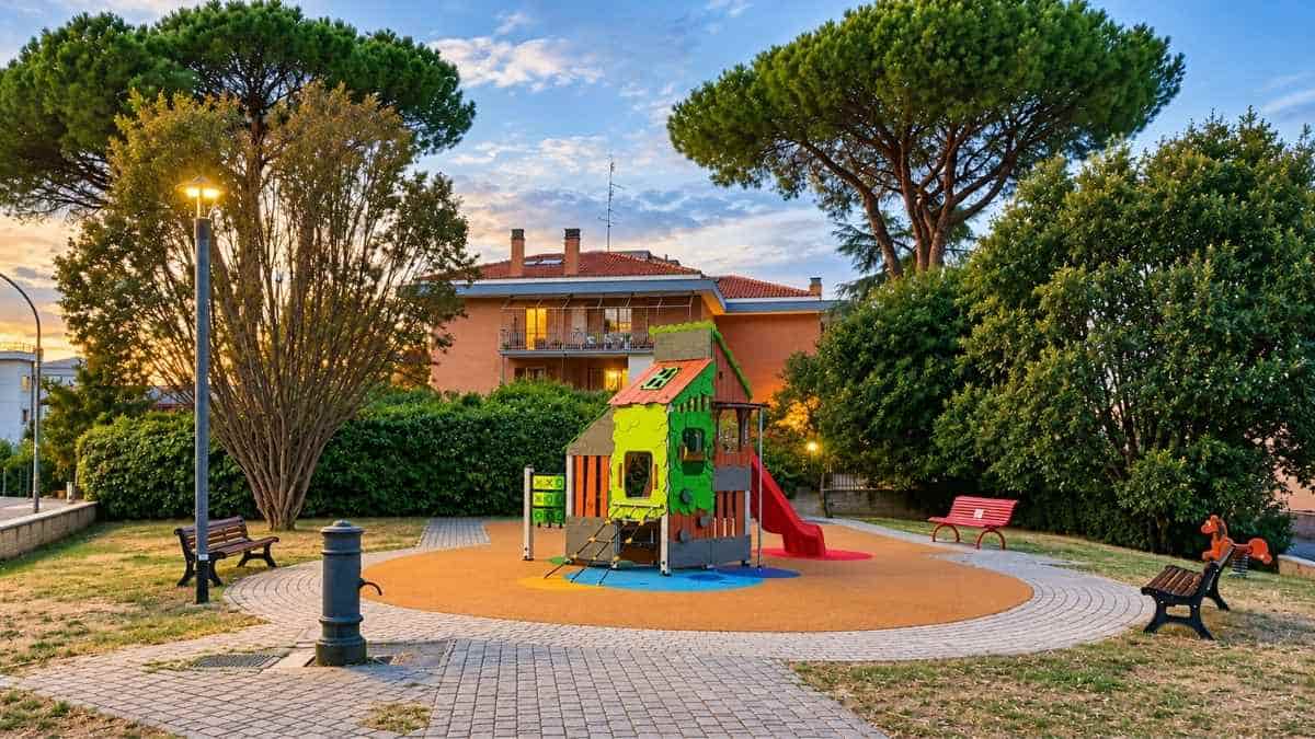Area giochi riqualificata del Parco della Pace tra i Popoli a Colle del Sole, Roma, con scivolo, struttura ludica e pavimentazione antitrauma.