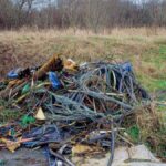 Accumulo di cavi elettrici abbandonati tra l'erba e la vegetazione a Le Vignole, nel Comune di Fiumicino.