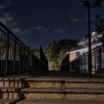 Magliana, ponte pedonale al buio tra via Giuseppe Belluzzo e via della Magliana, con scalinata e passerella scarsamente illuminate.