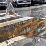 Marconi, attraversamento pedonale allagato tra via Grimaldi e via Aldini a Roma, con acqua davanti allo scivolo del marciapiede.