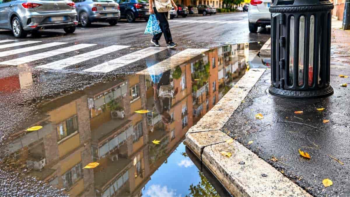Il ristagno d'acqua lungo il marciapiede e le strisce pedonali tra via Grimaldi e via Aldini, nel quartiere Marconi a Roma.