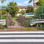 Ostia Antica, strisce pedonali davanti al ponticello in legno chiuso da una recinzione in via del Collettore Primario.