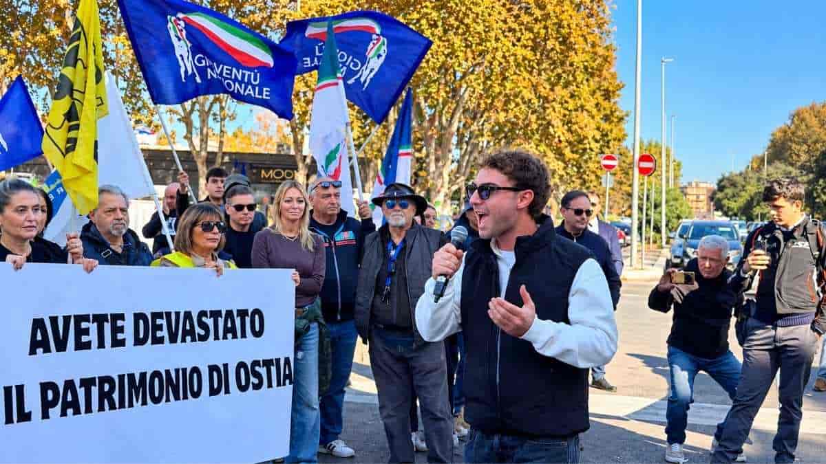 Andrea Parisi interviene al microfono durante la manifestazione di Giustizia X Ostia contro il degrado, davanti a cittadini, striscioni e bandiere.