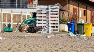 Ostia, rifiuti sulla sabbia vicino ai contenitori della raccolta differenziata e alle strutture della spiaggia libera del Marabù.