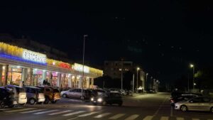 Ostia, via della Martinica di notte: attraversamenti pedonali, parcheggi e illuminazione stradale nei pressi di Parco Pallotta.