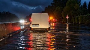 Pontina allagata a Borgo Isonzo: ricostruzione digitale di un furgone bianco che attraversa una carreggiata invasa dall'acqua.