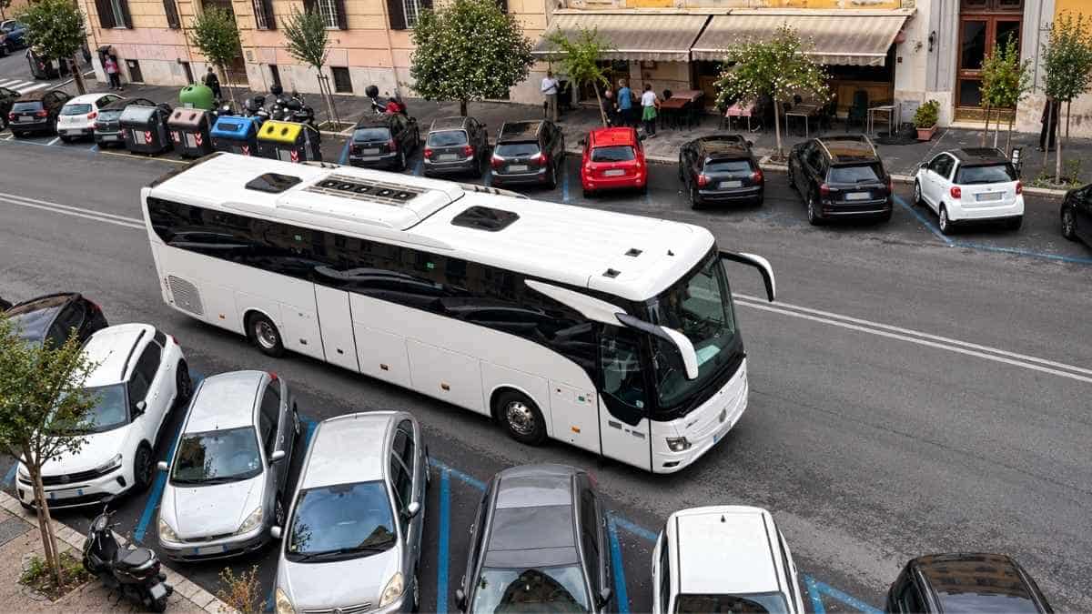 Pullman turistico in via della Giuliana, nel quartiere Prati a Roma, accanto alle automobili parcheggiate lungo la strada.