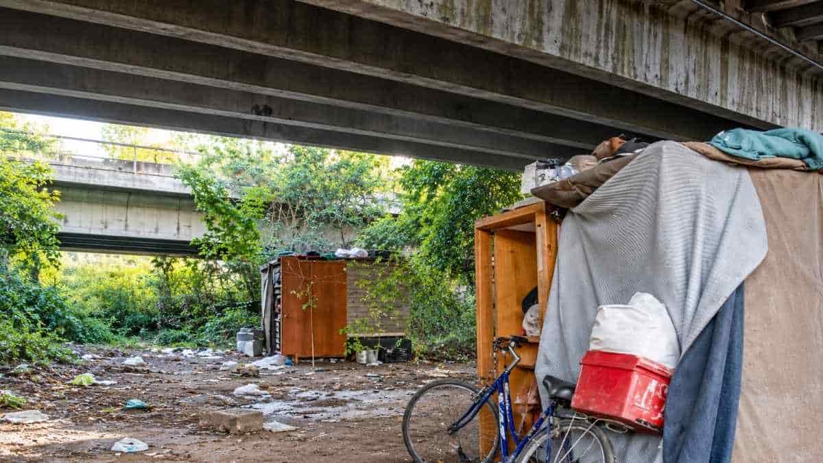 Roma, ripari di fortuna, bicicletta, mobili e coperte sotto il ponte di corso Francia, nell'area segnalata per la presenza di rifiuti.