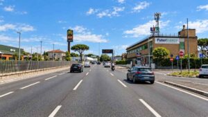 Traffico su via Anagnina a Roma, nel tratto compreso tra i civici 3 e 19, dove è stato segnalato il caso della rimozione di un impianto per la sicurezza dell’attraversamento pedonale.