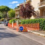 Roma, via Giannetto Valli nel quartiere Portuense, con transenne arancioni, segnaletica temporanea e area di cantiere lungo la strada.