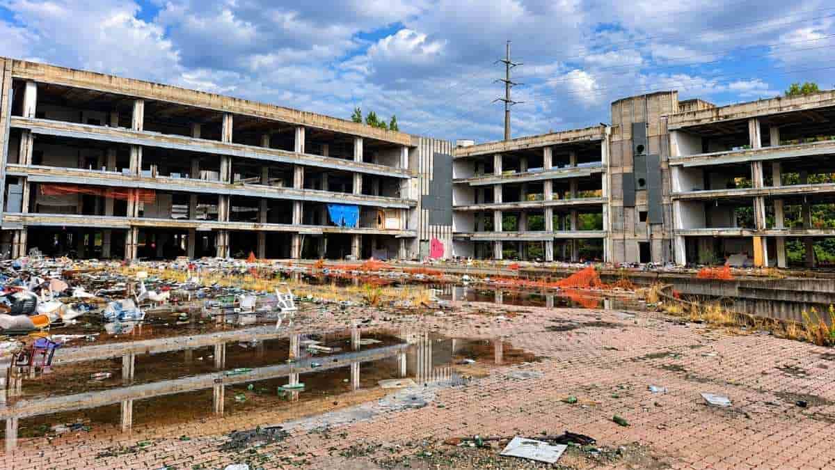 Tor Sapienza, edifici abbandonati di via Cesare Tallone con rifiuti, detriti e ristagni d'acqua nel cortile dell'ex complesso occupato.